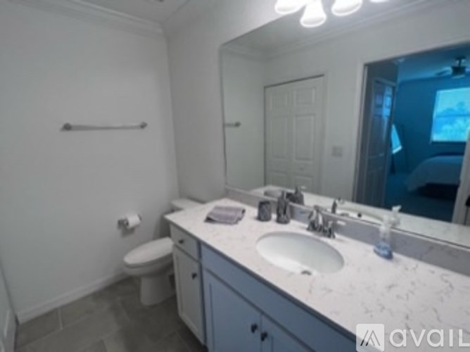 A bathroom with a toilet, sink, and mirror.