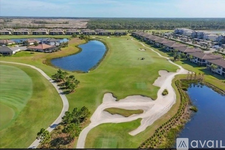 A golf course with a lake and a club house.