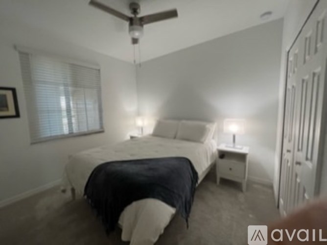 A bedroom with a bed, nightstand, and window.