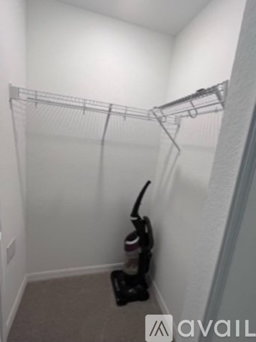 A vacuum cleaner is on the floor of a small room.