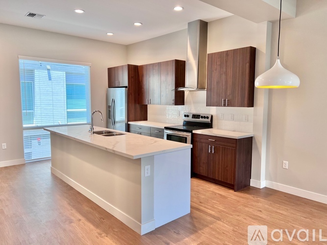 A modern kitchen with wooden cabinets and a white island.