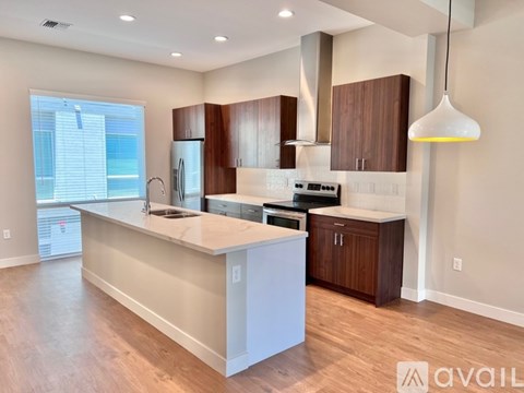 A modern kitchen with wooden cabinets and a white island.