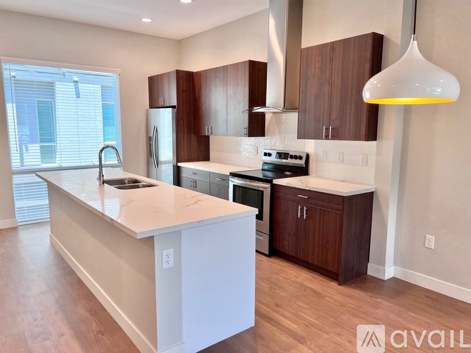 A kitchen with a white counter top and wooden cabinets.
