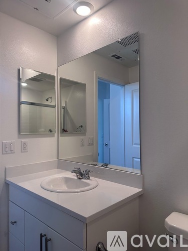 A bathroom with a sink, mirror, and toilet.