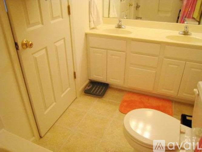 A bathroom with a toilet, sink, and a white door.