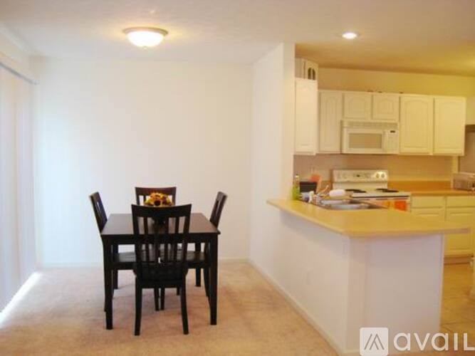 A kitchen with a table and chairs in the foreground.