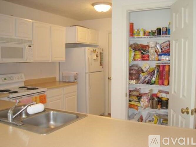 A kitchen with white cabinets and a white refrigerator.