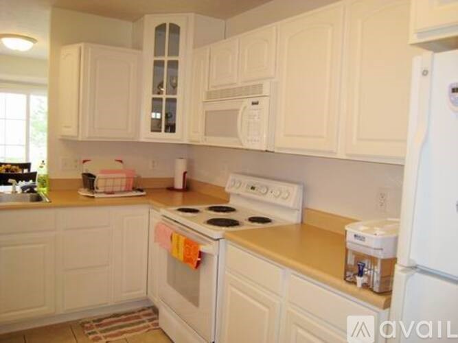 A kitchen with white cabinets and appliances.