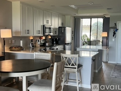 A modern kitchen with a dining table and chairs.