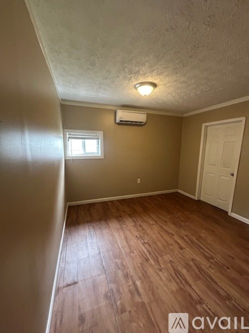 A room with wooden floors and a window.