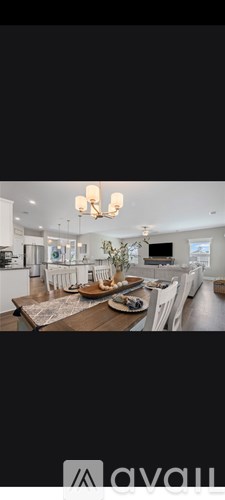 A modern living room with a wooden dining table and white chairs.