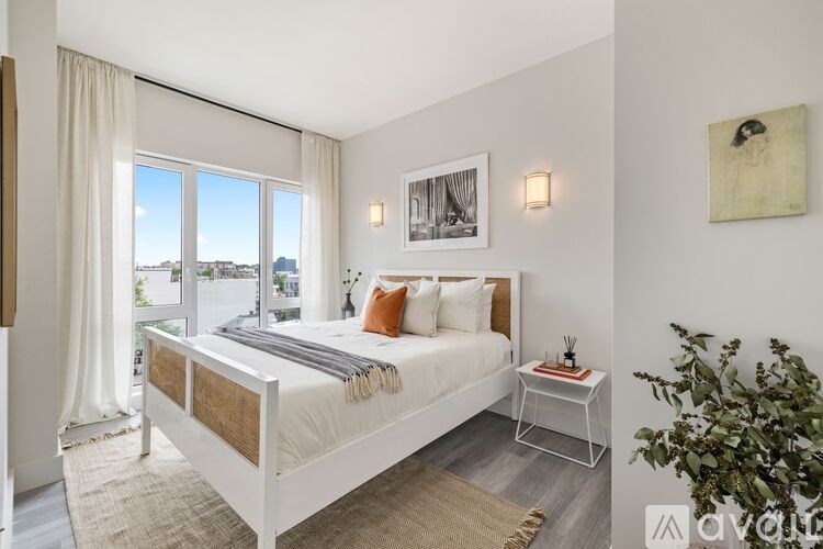 A bedroom with a large bed and a view of the city through the window.