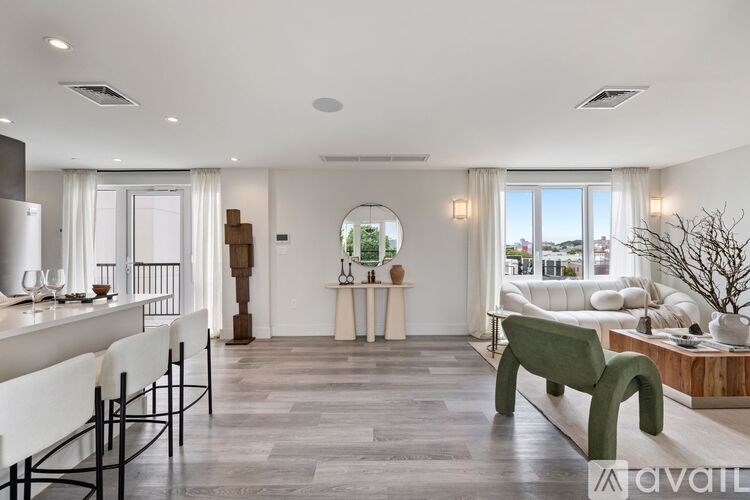 A modern living room with a green bench and a dining table with chairs.