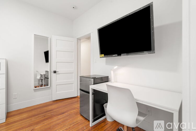 A bedroom with a bed, desk, and chair.