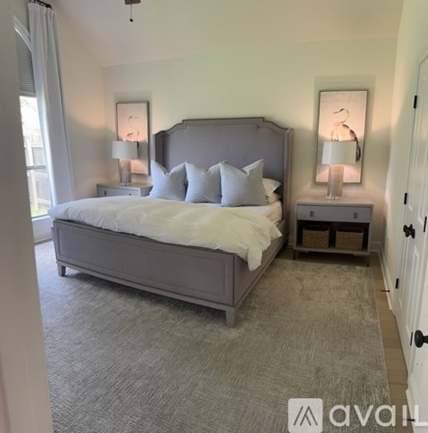 A bedroom with a large bed and two nightstands with lamps.