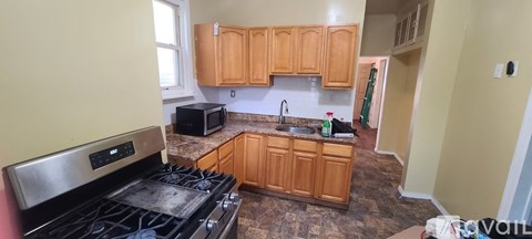 A kitchen with wooden cabinets and a black stove top.