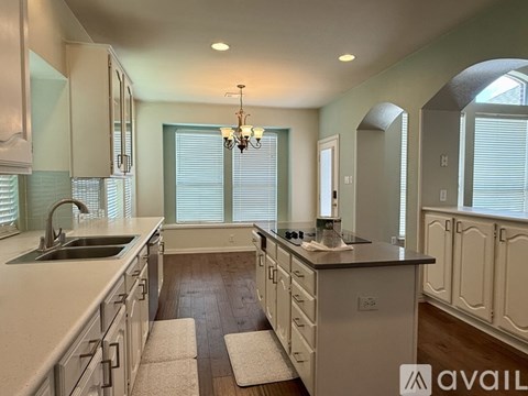 Two black ovens in a kitchen with white cabinets.
