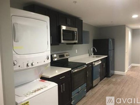 A kitchen with black cabinets and a white oven.
