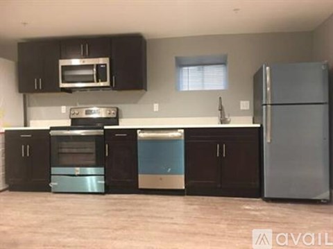 A kitchen with black cabinets and a blue dishwasher.