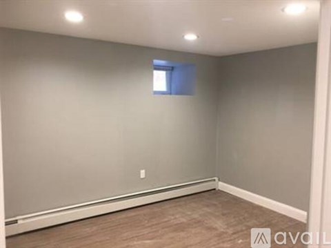A room with a window and a wooden floor.