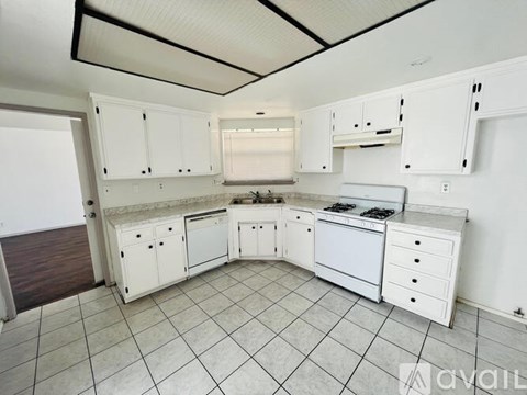 A kitchen with white cabinets and appliances.
