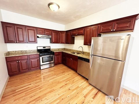 A kitchen with wooden floors and stainless steel appliances.