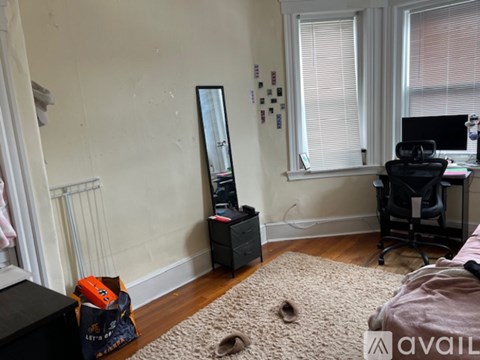 A room with a desk, chair, and a mirror on the wall.