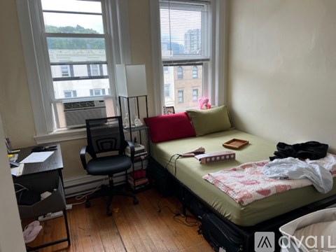 A bedroom with a bed, chair, and desk.