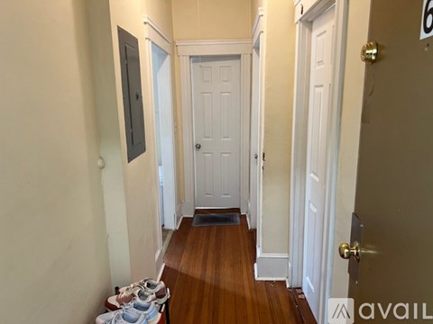A hallway with a white door and a brown floor.