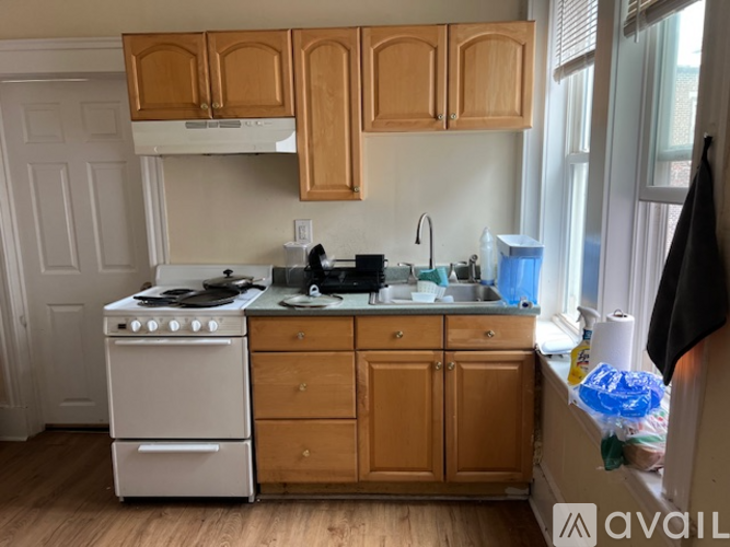 A kitchen with wooden cabinets and a white stove.