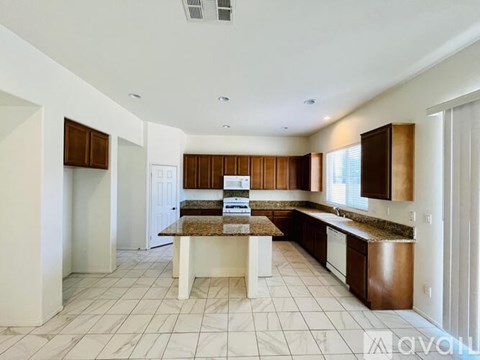 A kitchen with brown cabinets and a marble island.