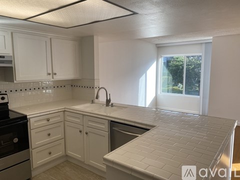 A kitchen with white cabinets and a tiled backsplash.