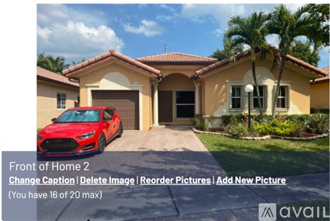 A red car is parked in front of a house.