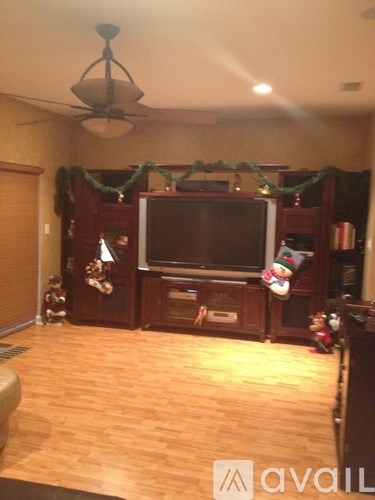 A living room with a television and a ceiling fan.