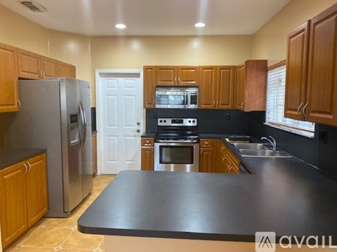 A kitchen with wooden cabinets and a black countertop.