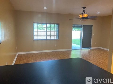 A spacious room with a black floor and a ceiling fan.