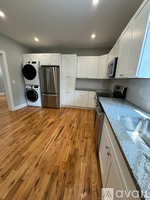 A kitchen with wooden floors and white cabinets.