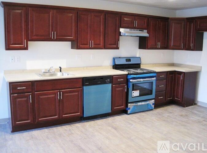 A kitchen with brown cabinets and a white countertop.