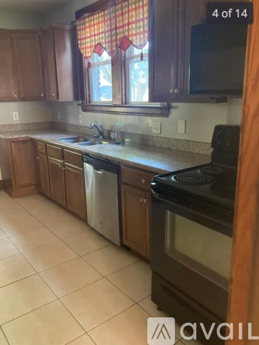 A kitchen with wooden cabinets and a black stove top oven.