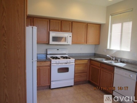 A kitchen with wooden cabinets and white appliances.