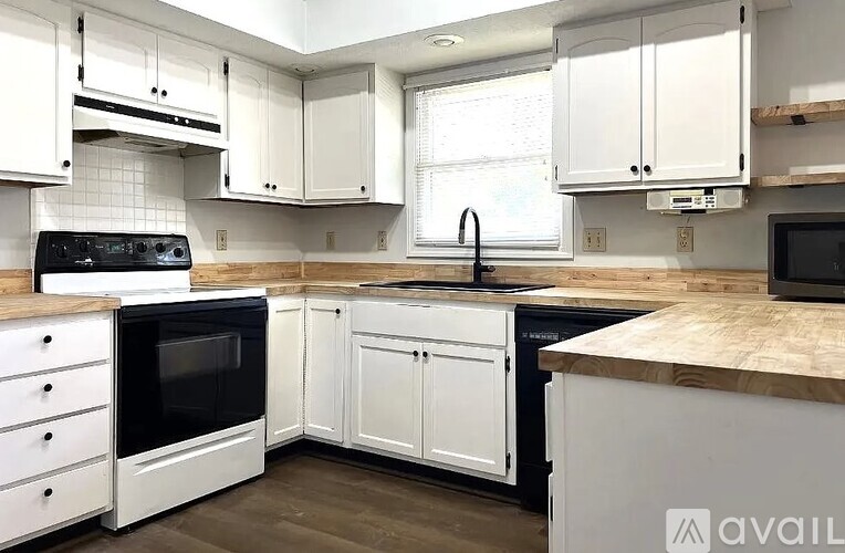 A kitchen with white cabinets and a black oven.