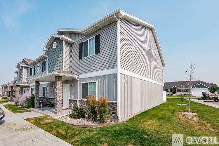 A house with a grey and green exterior is for sale.
