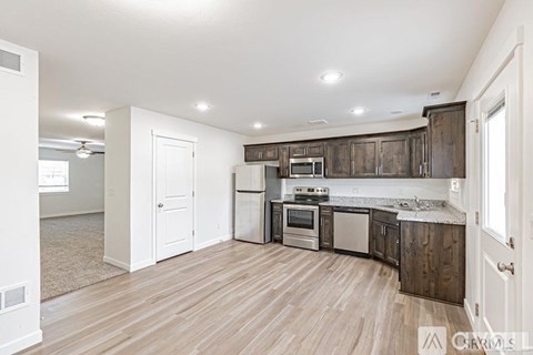 A kitchen with wooden cabinets and a white door.