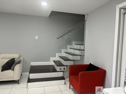 A living room with a red chair and a white couch.