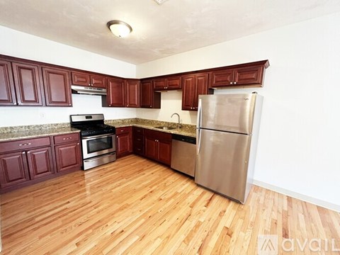 A kitchen with wooden floors and stainless steel appliances.