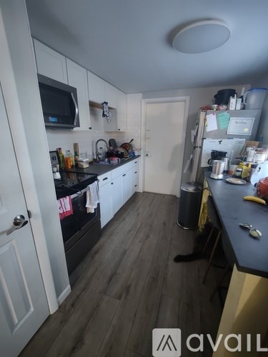 A kitchen with a black countertop and white cabinets.