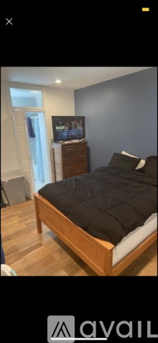 A bedroom with a bed, dresser, and a television on the dresser.