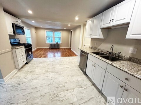 A kitchen with a marble floor and white cabinets.