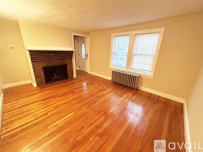 A room with a fireplace and wood flooring.