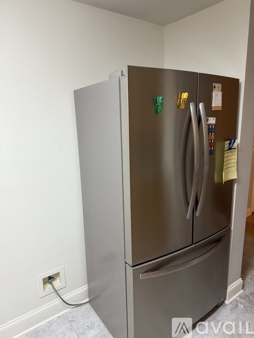 A stainless steel refrigerator with a white door and a white handle.